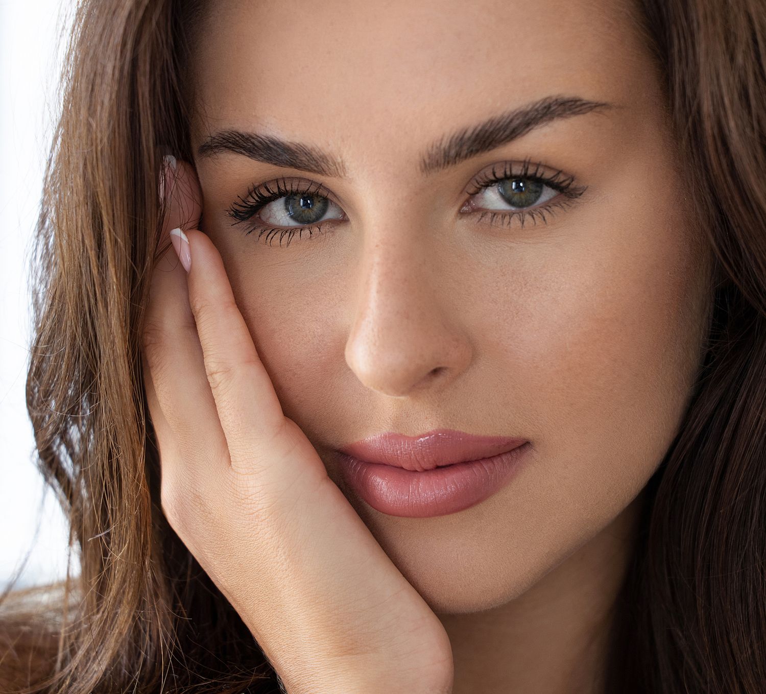 Orange County med spa model with elegant earrings and radiant skin.