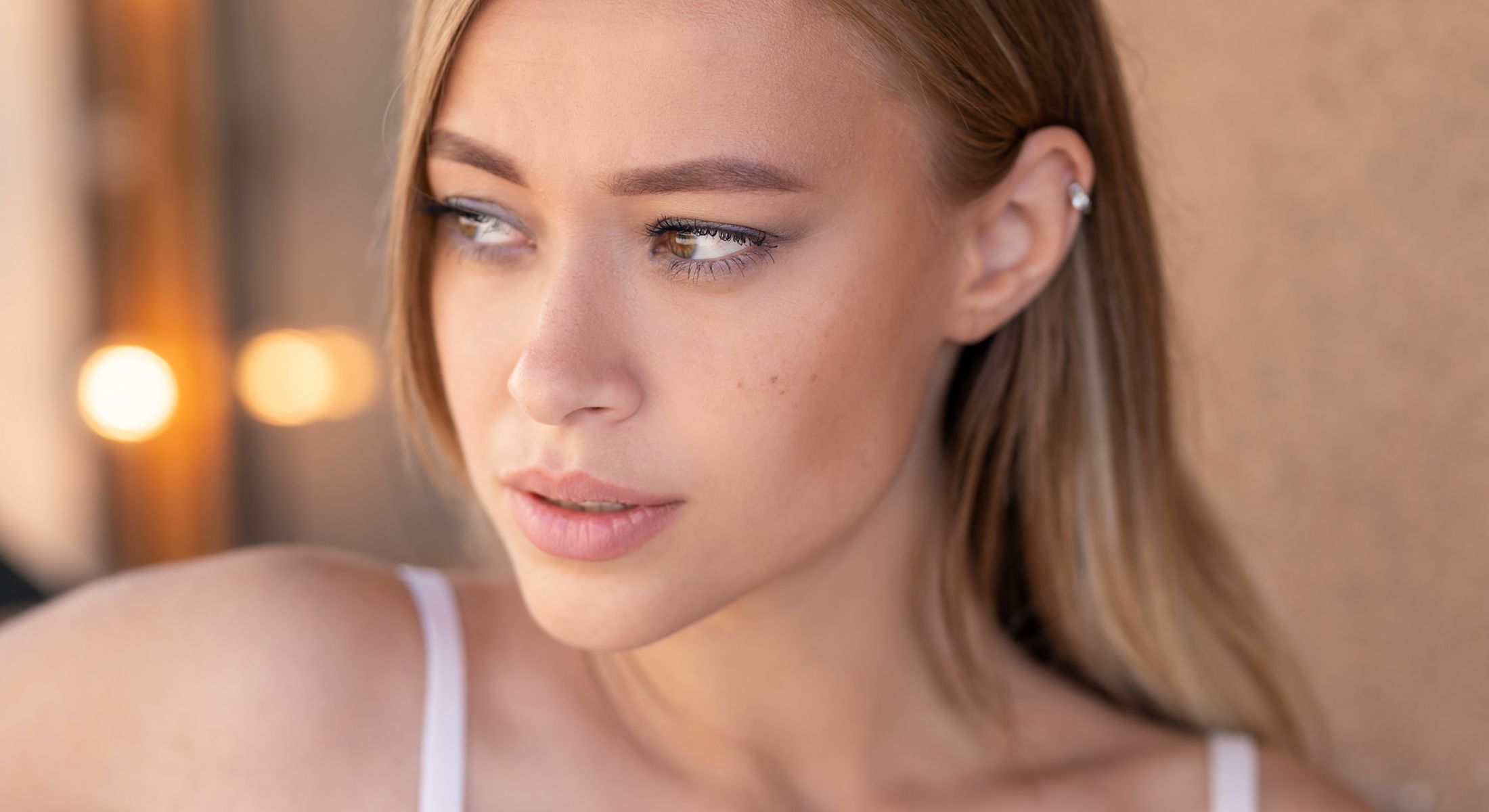 Woman with long hair looking thoughtfully to the side.